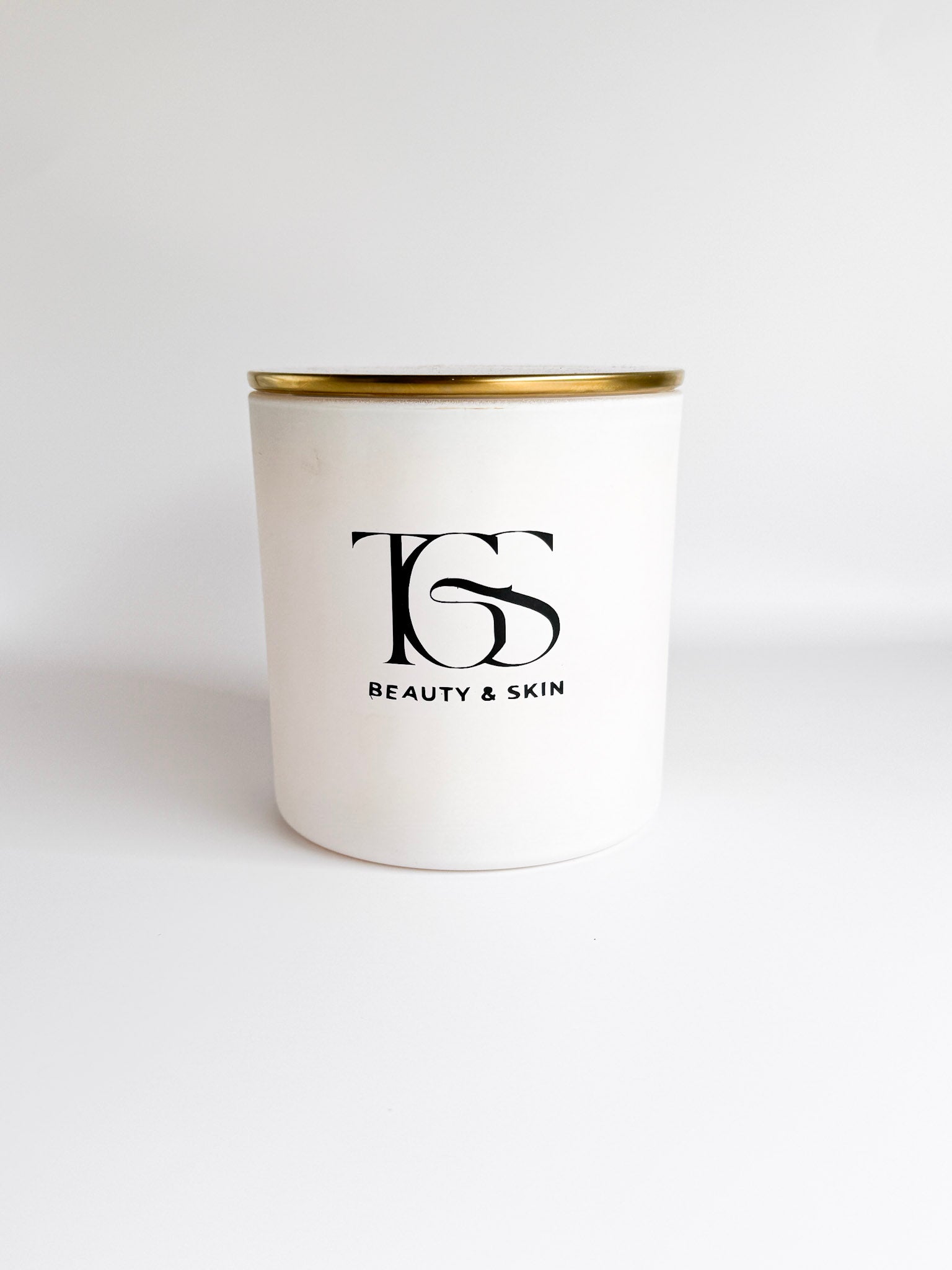 Close-up view of the white candle jar highlighting its elegant gold lid.
