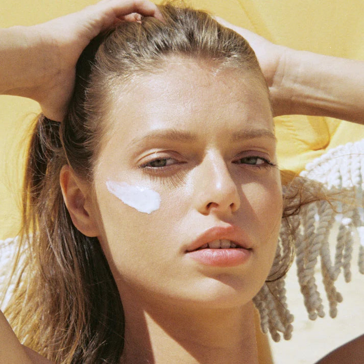 Close-up of womanβs face with sunscreen applied to cheeks.