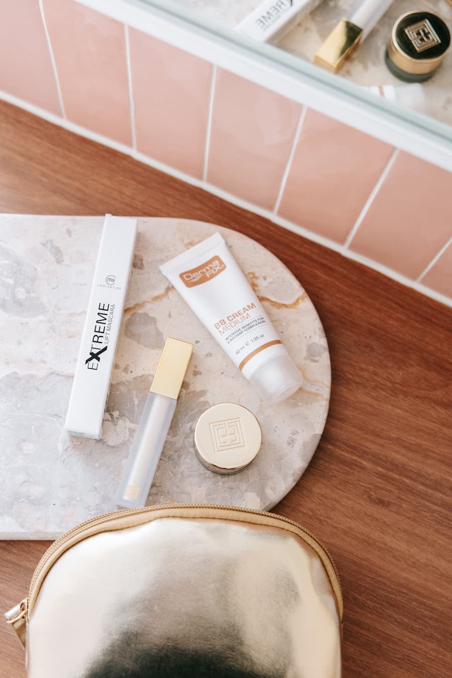 Cosmetic products on a marble tray with a gold pouch on a wooden surface  at TGS Beauty & Skin salon in Perth.
