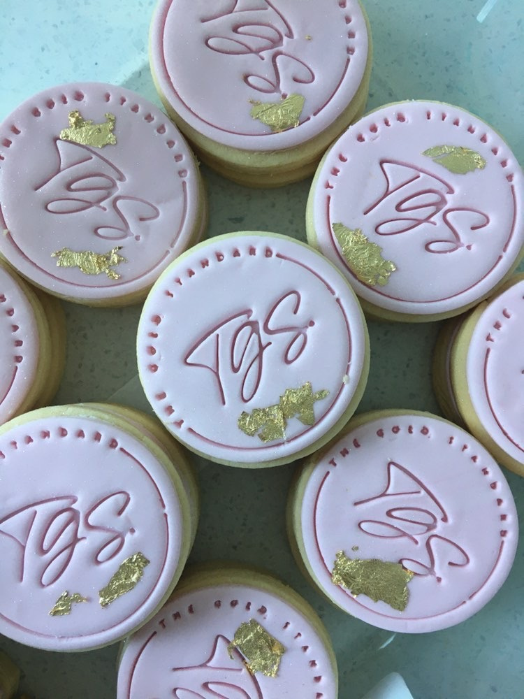 Pink iced cookies with TGS Beauty & Skin logo and gold leaf, custom treats for clients in Perth
