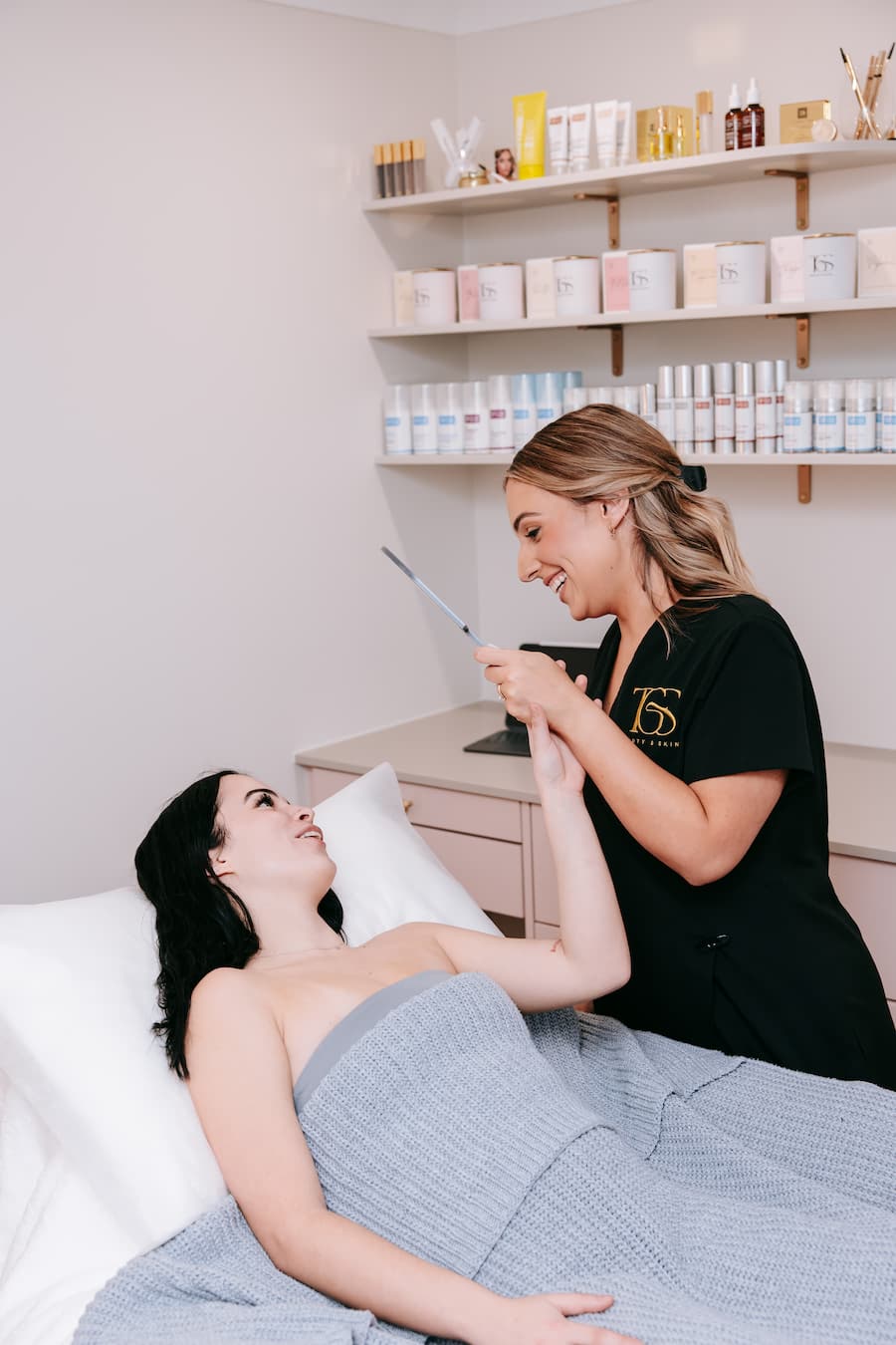 TGS Beauty therapist discussing treatment plan with client in makeover bundle room at Perth clinic