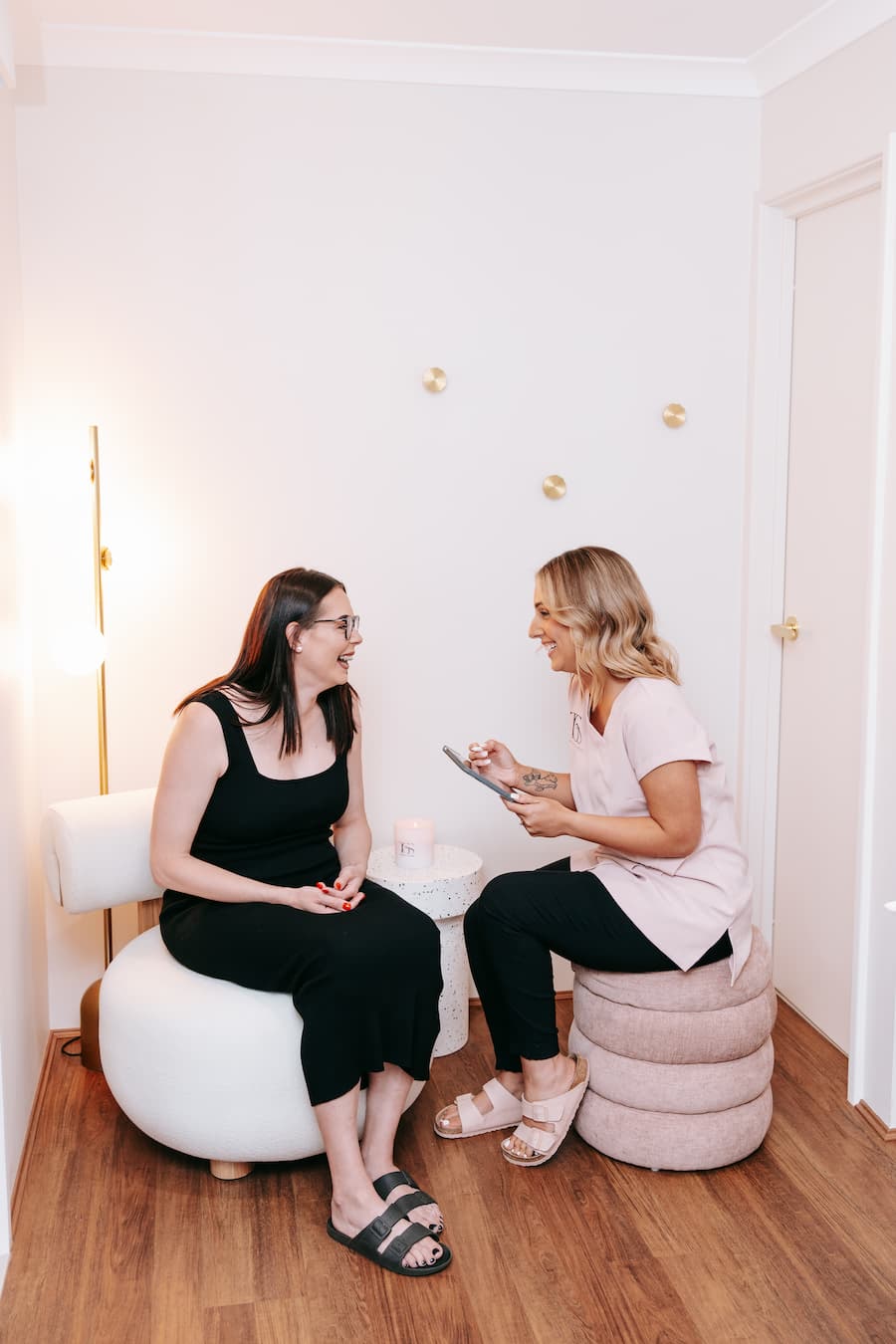 TGS Beauty therapist conducting a friendly skin consultation with client in Perth clinic lounge