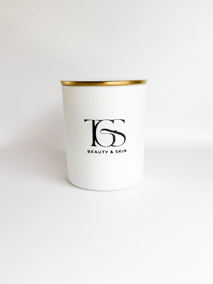 White candle jar with gold lid clearly showing branding and design.