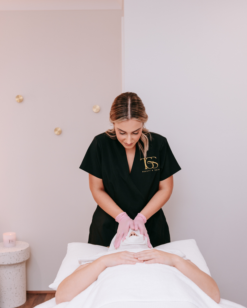 Woman with glowing, hydrated skin receiving a luxury facial at The Gold Standard Beauty & Skin in Perth. Relaxing spa treatment with clinical-grade skincare for radiant results.