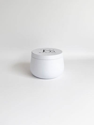 Small white travel-sized tin candle, compact and stylish.